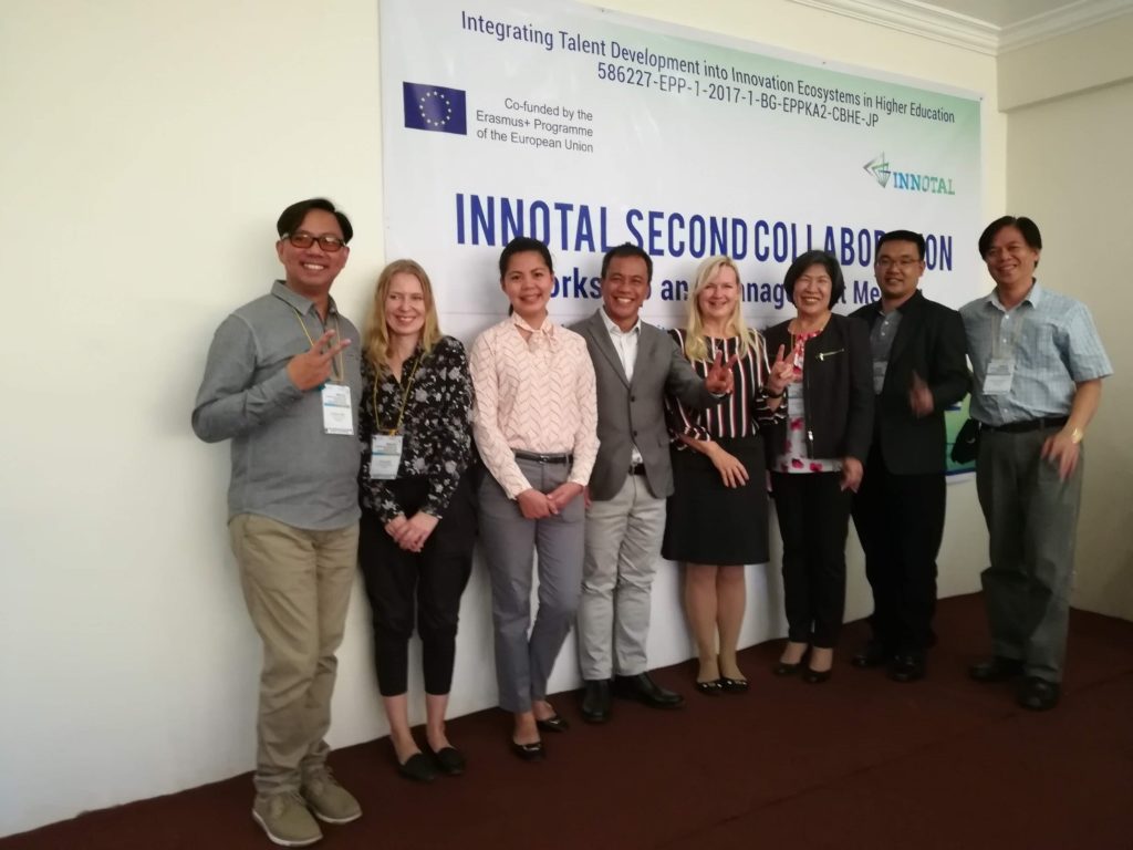 Group of people standing in front of the big sign that reads "Innotal second collaboration".