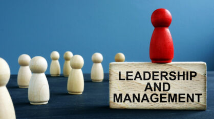 Leadership and management written on a wooden block.