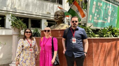 Three persons from VAMK delegation in front of the Gandhi statue at Delhi Public Highschool.