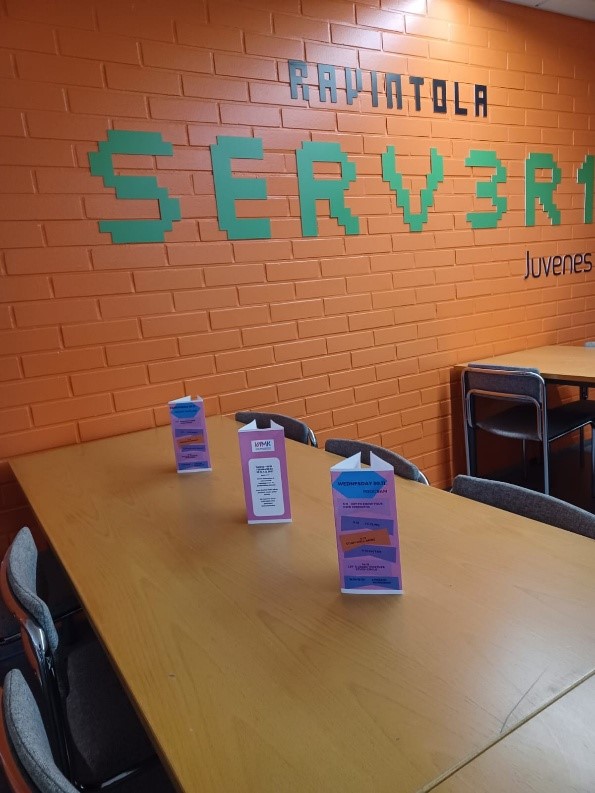 Tapahtuman värikkäitä esitteitä on aseteltu riviin koulun ruokalan ravintola Serverin pöydälle.