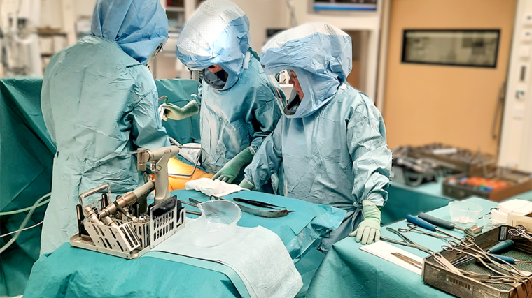 Tekoniveloperaatio leikkaussalissa. Kirurgi ja hoitajat sinisissä asuissaan.