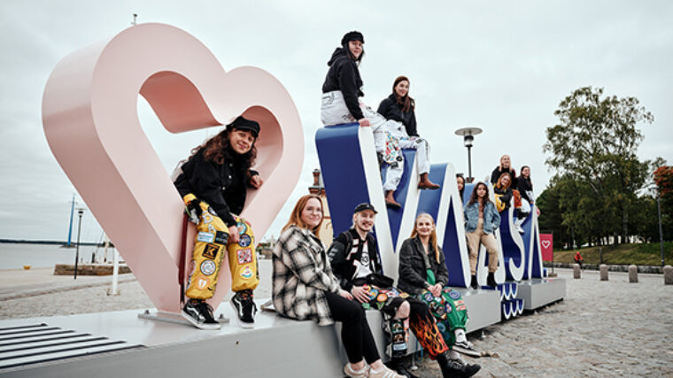 VAMKin opiskelijoita haalareissa Vaasassa Sisäsatamassa Vaasa-kyltin ympärillä.