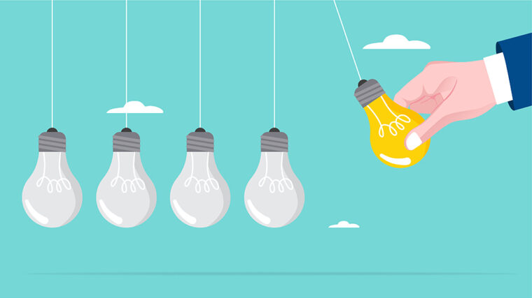 Viisi hehkulamppua roikkuu naruista sinistä taivasta vasten. Neljä lamppua ovat harmaita, ja yksi keltainen lamppu, jota pitelee käsi kuvan oikeassa reunassa. Taustalla näkyy muutamia pilviä.