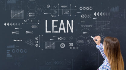 Nainen kirjoittaa liitutaululle, jossa lukee isolla LEAN