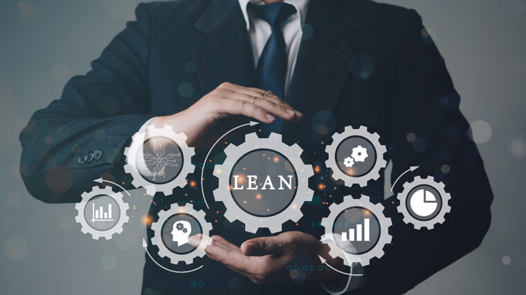 Person in a business suit holding virtual gears with the word “LEAN” and icons representing process improvement and analytics.