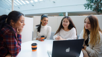 Students at VAMK sitting by a laptop.