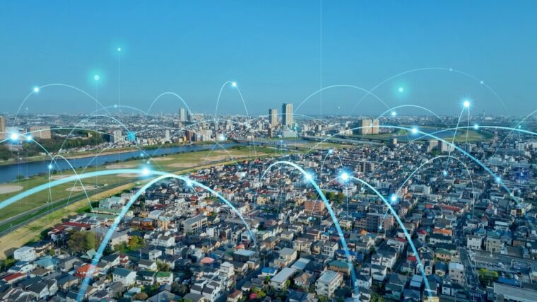 Aerial view of a city with a digital network overlay showing interconnected locations and data connectivity across an urban area.